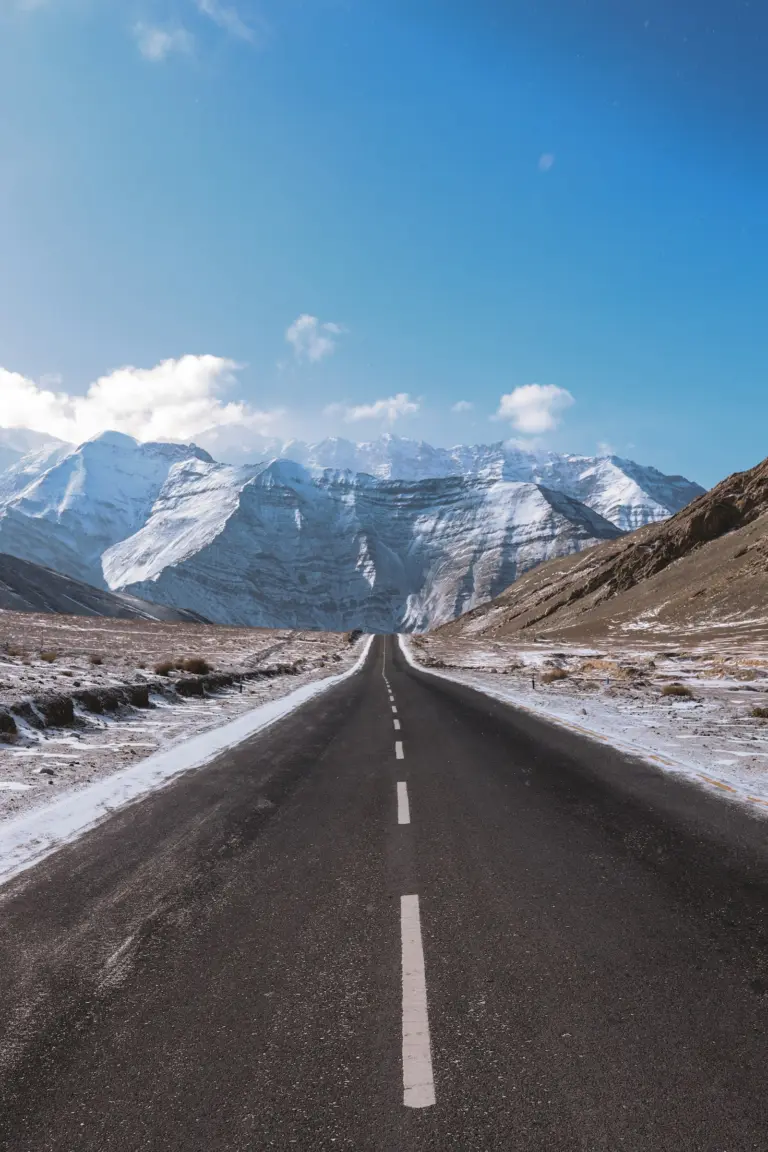 Empty road running towards a mountain range near Leh